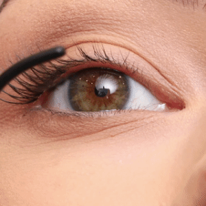 Prikaz bliskog plana modela koji nanosi trepavice u grozdovima